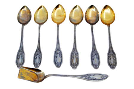  Conjunto de seis colheres de café em prata e pá de açúcar com as conchas douradas e cabos relevados.