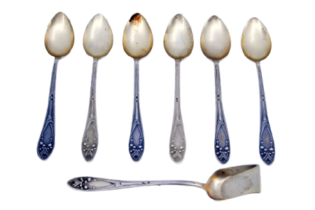  Conjunto de seis colheres de café em prata e pá de açúcar com conchas douradas e cabos relevados.