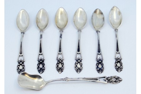  Conjunto de seis colheres de café e pá de açúcar em prata com os cabos recortados.