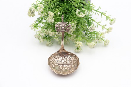 Colher em prata com gravura em alto relevo na concha e pomo em forma de cupido