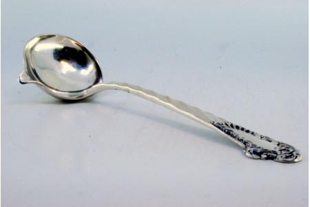 Colher para molhos em prata para destros com motivos florais e cabo ondeado com voluta para monograma. 