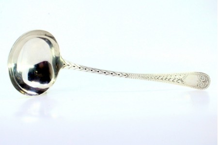 Concha de sopa em prata com relevos ao longo do cabo envolvendo cartela para monograma.