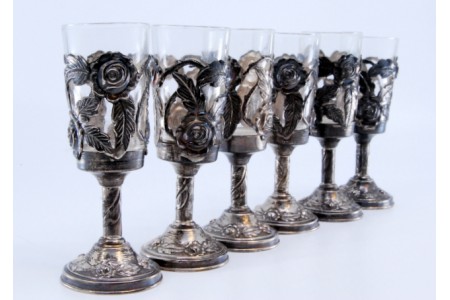 Conjunto de seis copos em prata com interior em vidro e relevos com flores recortadas.