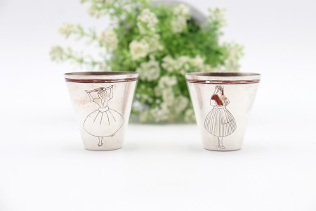 Par de pequenos copos de prata com gravações de trajes tradicionais