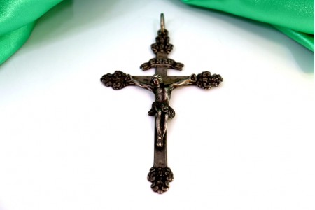 Crucifixo em prata com relevos e aplicações, argola de suspensão.