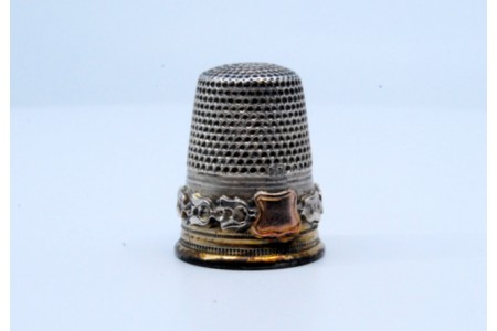 Dedal em prata com brazão e relevado na envolvência.