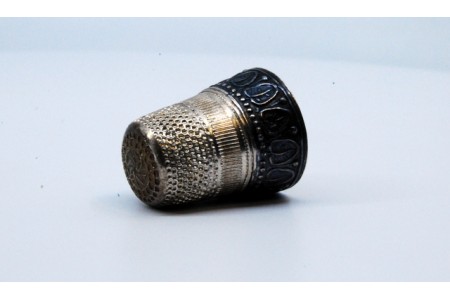 Dedal em prata com folhas relevadas.