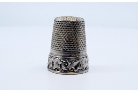 Dedal em prata relevada com figuras.