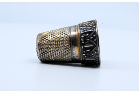 Dedal em prata com relevo.