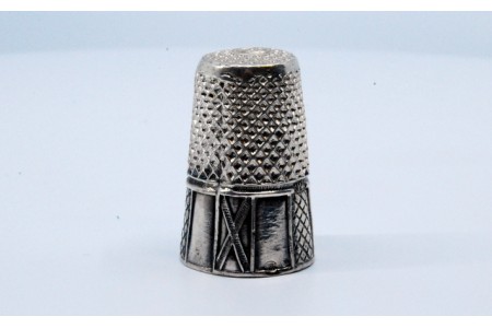 Dedal em prata com relevo.