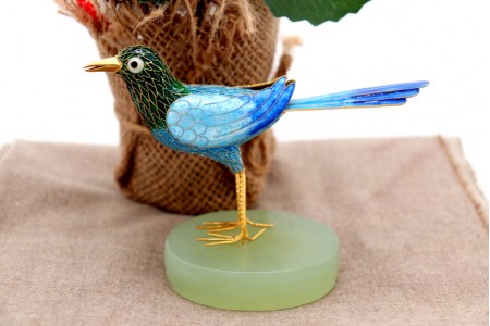 Pássaro em prata coberto por esmalte colorido sobre base em pedra 