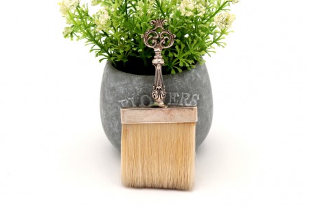 Vassoura em prata com relevos e recortes na pega