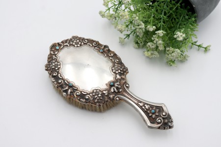 Escova de cabelo em prata com elementos florais em alto relevo e turquezas