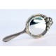Espelho de mão em prata relevada com laço e frisos na envolvência.