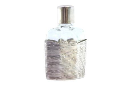 Frasco de perfume em vidro com suporte e tampa em prata com frisos.