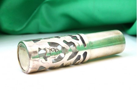 Frasco de perfume em forma de spray com estrutura em prata recortada e alma 