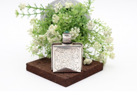 Frasco de perfume de vidro revestido a prata com rosas gravadas nas duas faces