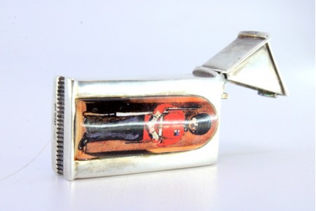 Fosforeira em prata na forma de guarita com figura de guarda inglês em esmalte.