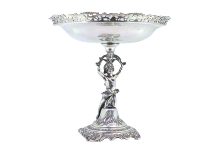 Fruteira centro de mesa em prata com gradinha e gravados no centro suportado por figura feminina sobre base relevada com volutas.