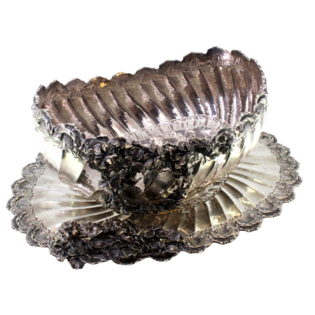  Fruteira em prata com aplicações de motivos florais relevados, frisos concheados, corpo espiralado e assente em base lisa de forma elíptica.