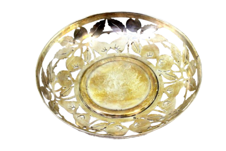 Fruteira em prata dourada com motivos florais recortados.