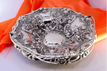  Fruteira em prata com relevos concheados e motivos florais envolvendo cartelas 