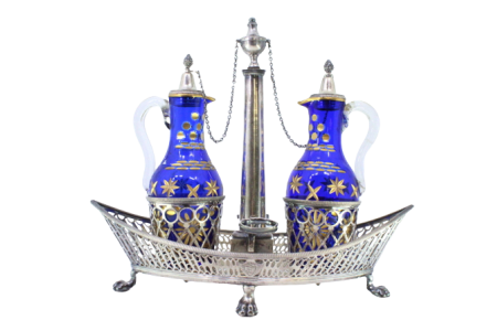  Galheteiro com estrutura em prata com gradinha e duas galhetas em vidro azul com apontamentos em dourado, assente em base em forma de nave