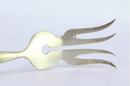 Garfo de servir peixe em prata com quatro dentes e frisos ao longo do cabo relevado.