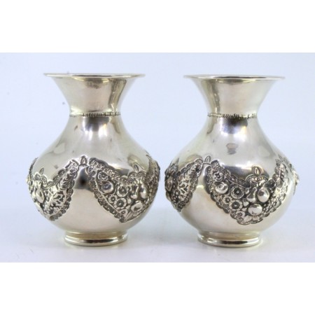 Conjunto de jarras pequenas em prata com motivos florais e grinaldas relevadas.
