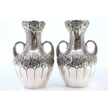 Conjunto de par de jarras pequenas em prata com motivos florais e grinaldas relevadas com duas pegas.