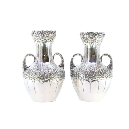 Conjunto de par de jarras pequenas em prata com relevos florais e duas pegas.