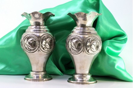 Par de jarras com bordos ondeados, motivos florais relevados assentes em bases