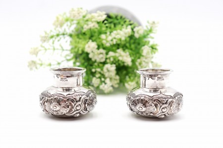 Par de jarrinhas em prata com elementos florais em alto relevo.