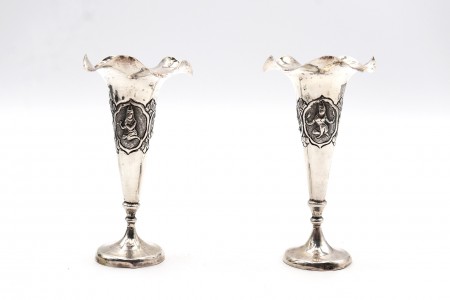 Par de jarras altas em prata de bocais ondeados e figuras divinas em relevadas.