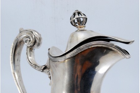 Jarro em prata liso com pomo na tampa basculante e base circular.