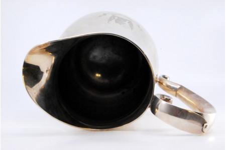 Jarro de água em prata lisa e com pequenos frisos, assente em base circular.