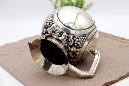 Jarro de vinho bojudo em prata com relevos de cachos de uvas e parras