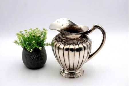Jarro de agua bojudo em prata gomado com relevos florais e base circular com frisos