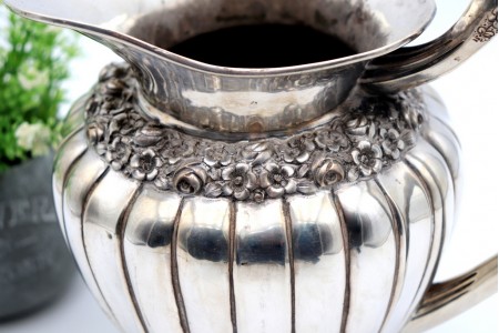 Jarro de agua bojudo em prata gomado com relevos florais e base circular com frisos