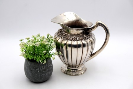 Jarro de agua bojudo em prata gomado com relevos florais e base circular 
