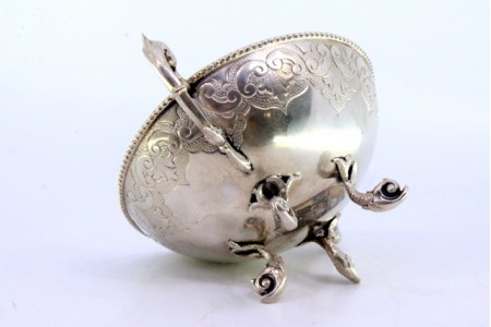 Bomboneira em prata com gravados, asas recortadas e assente sobre quatro pés em forma de peixes.