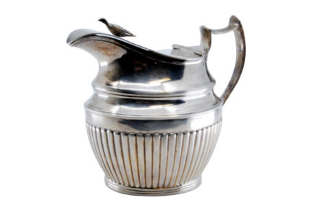 Leiteira em prata canelada em meio corpo com pomo na tampa e relevo na base.