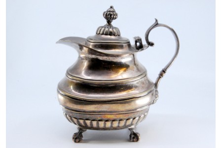 Bule liso no corpo superior e gomado na parte inferior, pomo na tampa e assente sobre quatro pés em forma de garras.