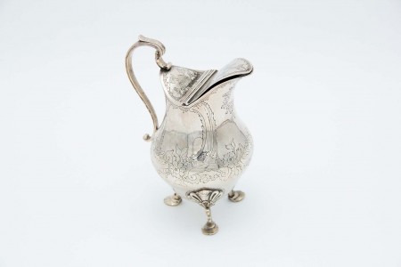 Leiteira em prata relevada com três pés alteados de suporte