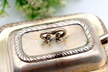 Manteigueira em prata com frisos torcidos no prato e na tampa com pomo e faca.