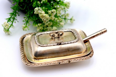 Manteigueira em prata com frisos torcidos no prato e na tampa com pomo e faca.