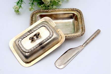 Manteigueira de prata com frisos torcidos no prato e na tampa com pomo e faca.