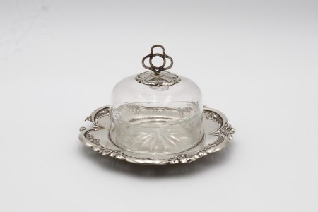 Manteigueira em base de prata relevada, alma de vidro lapidado e tampa com pomo recortado.