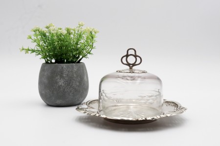 Manteigueira em base de prata relevada, alma de vidro lapidado e tampa com pomo recortado.