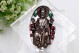 Moldura em prata com figura religiosa e pedras coloridas incrustadas